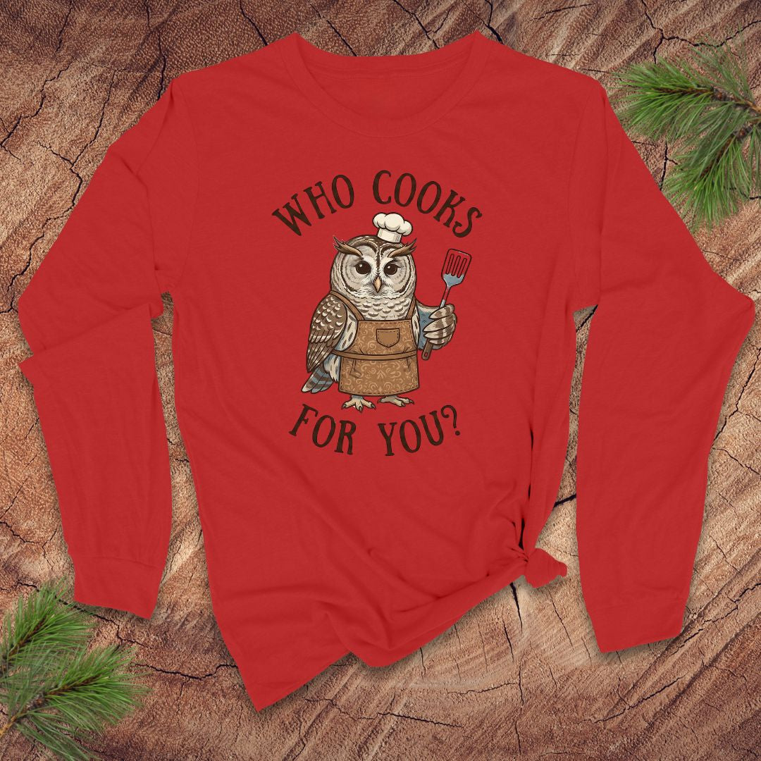 Red long-sleeve shirt with an owl graphic and text 'who cooks for you' on a wooden surface