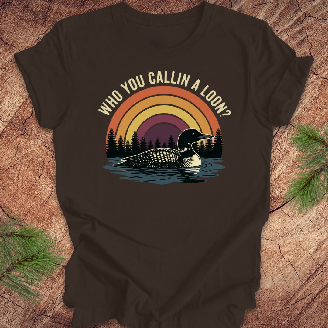 Brown t-shirt with a loon graphic and text 'who you callin a loon' on a wooden surface
