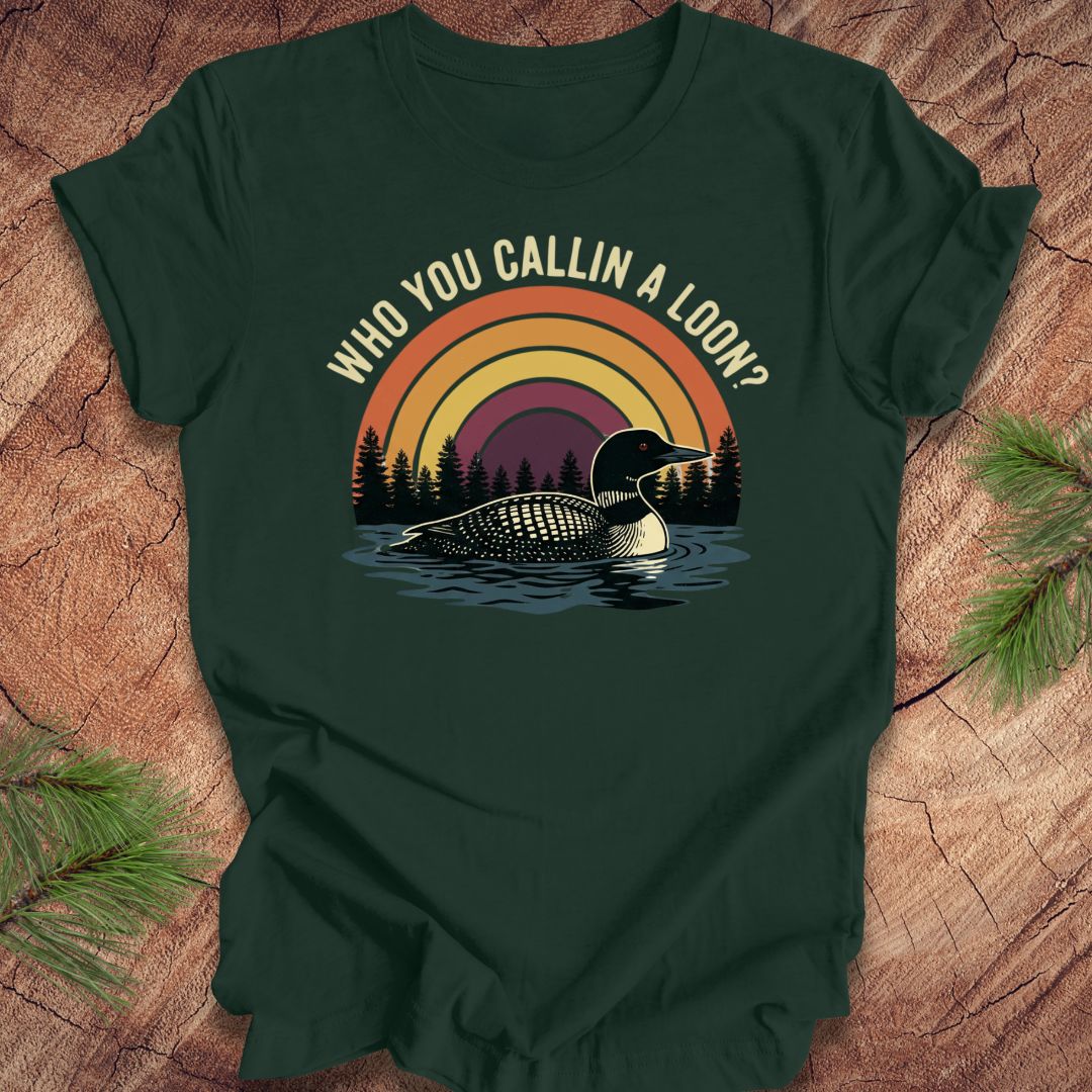 Green t-shirt with a loon graphic and text 'who you callin a loon' on a wooden surface