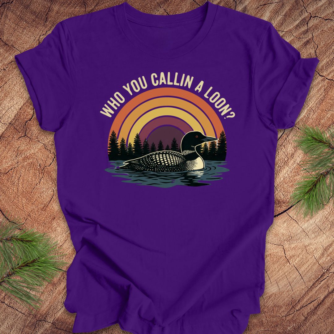 Purple t-shirt with a loon graphic and text 'who you callin a loon' on a wooden surface