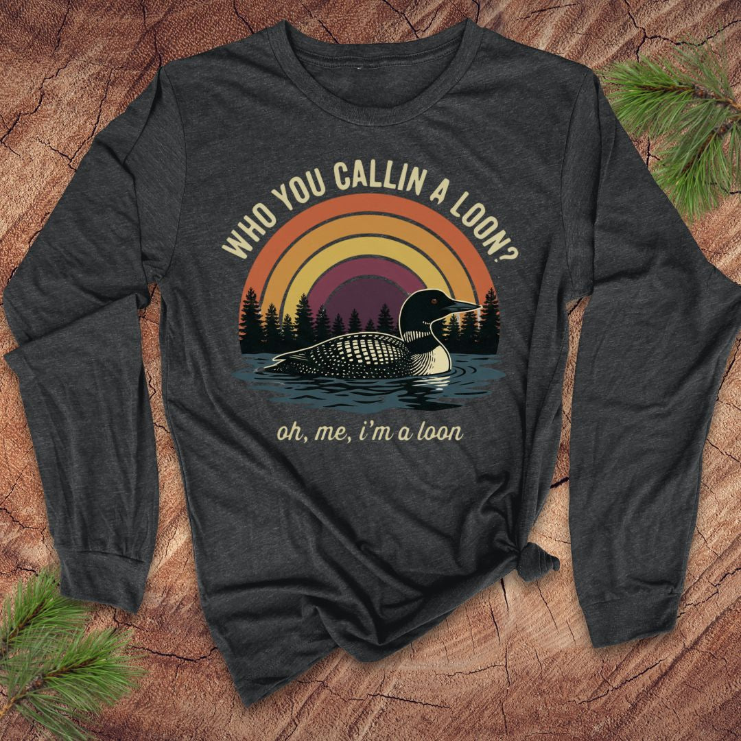 Dark gray long-sleeve shirt with loon graphic and text on a wooden surface