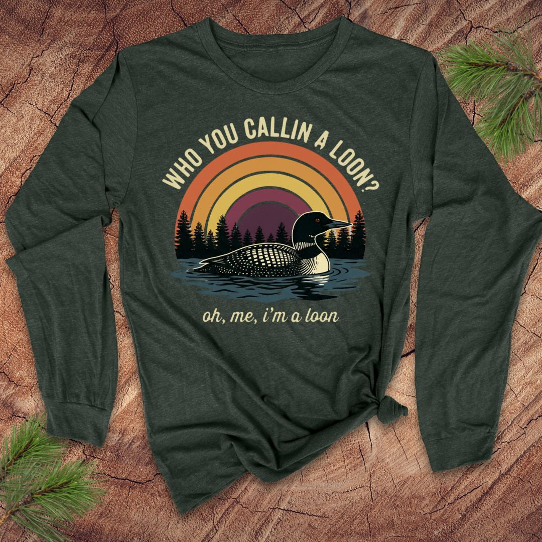 Green long-sleeve shirt with loon graphic and text on a wooden surface