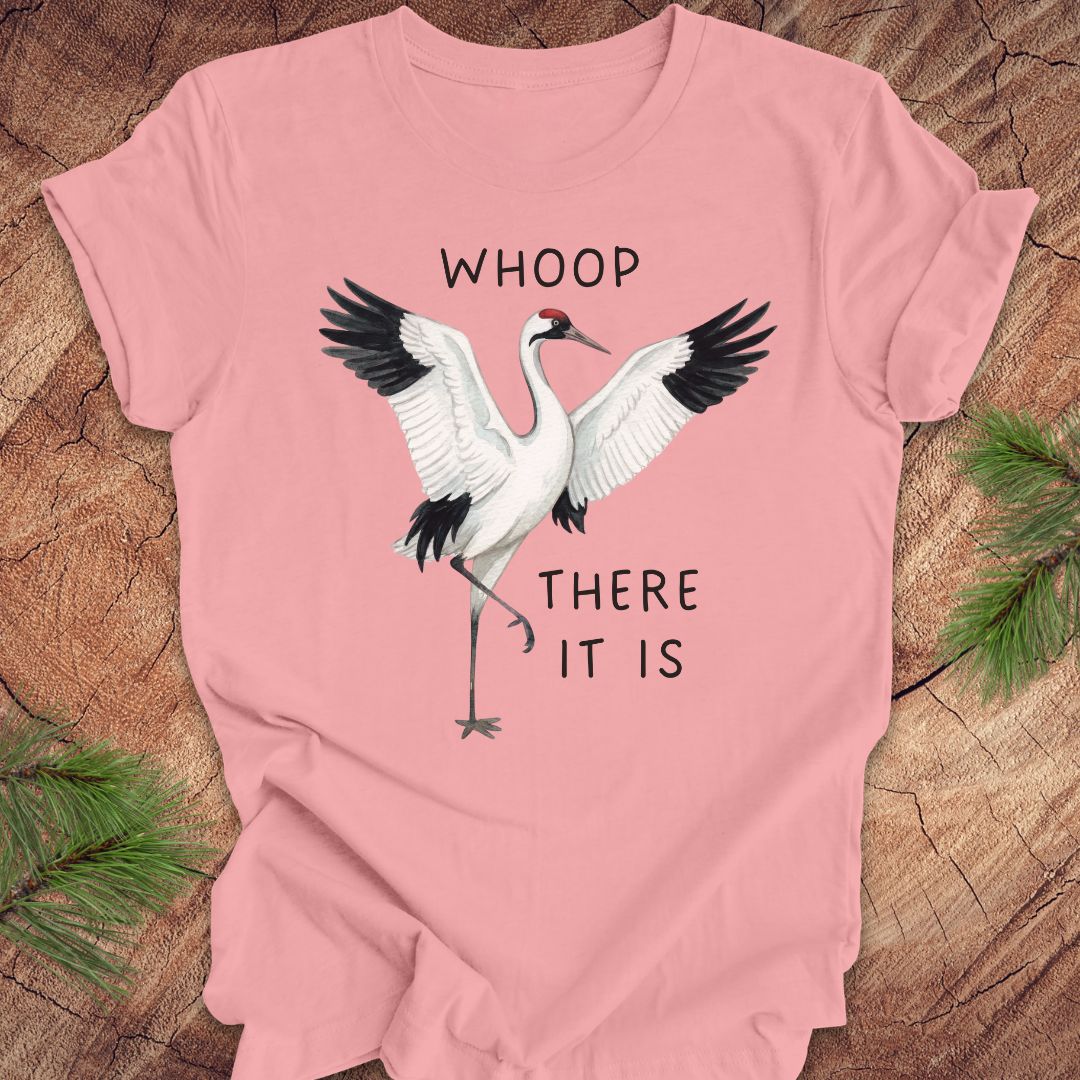  Pink t-shirt with a crane graphic and text, 'whoop there it is' on a wooden surface