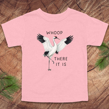Pink t-shirt with a crane graphic and text on a wooden surface