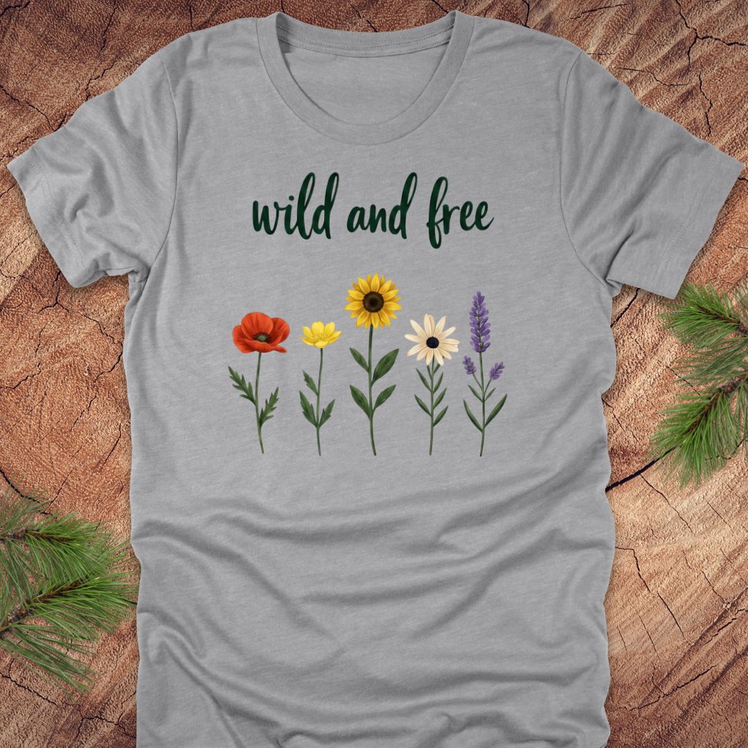 Gray t-shirt with floral design and 'wild and free' text on a wooden surface