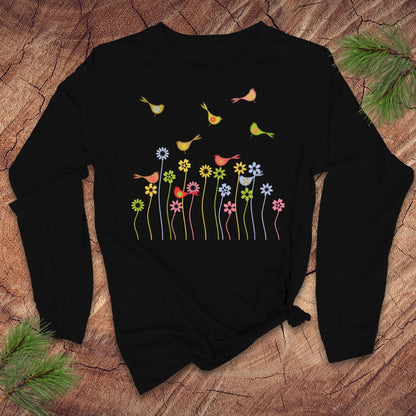 Black long-sleeve tshirt with colorful floral and bird design on a wooden surface