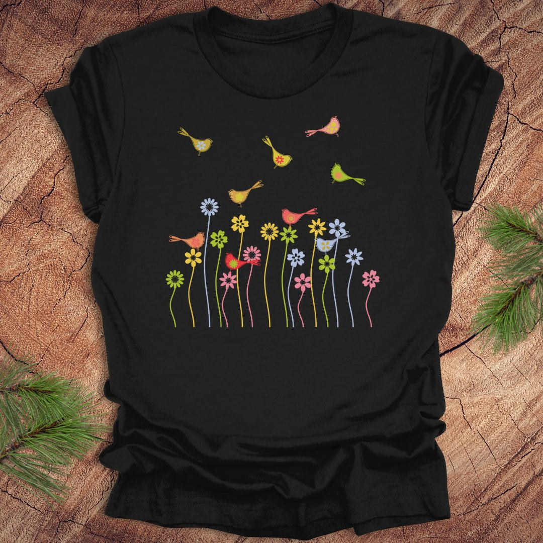 Black t-shirt with colorful bird and flower design on a wooden surface