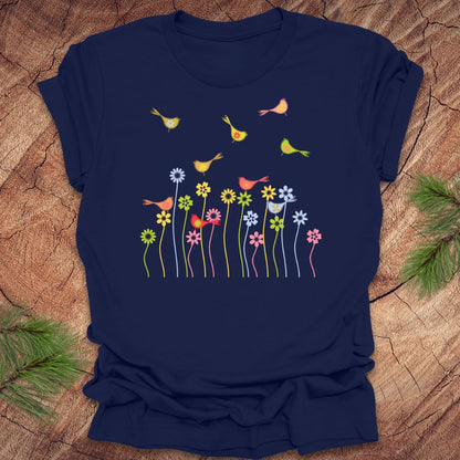 Navy blue t-shirt with colorful bird and flower design on a wooden surface