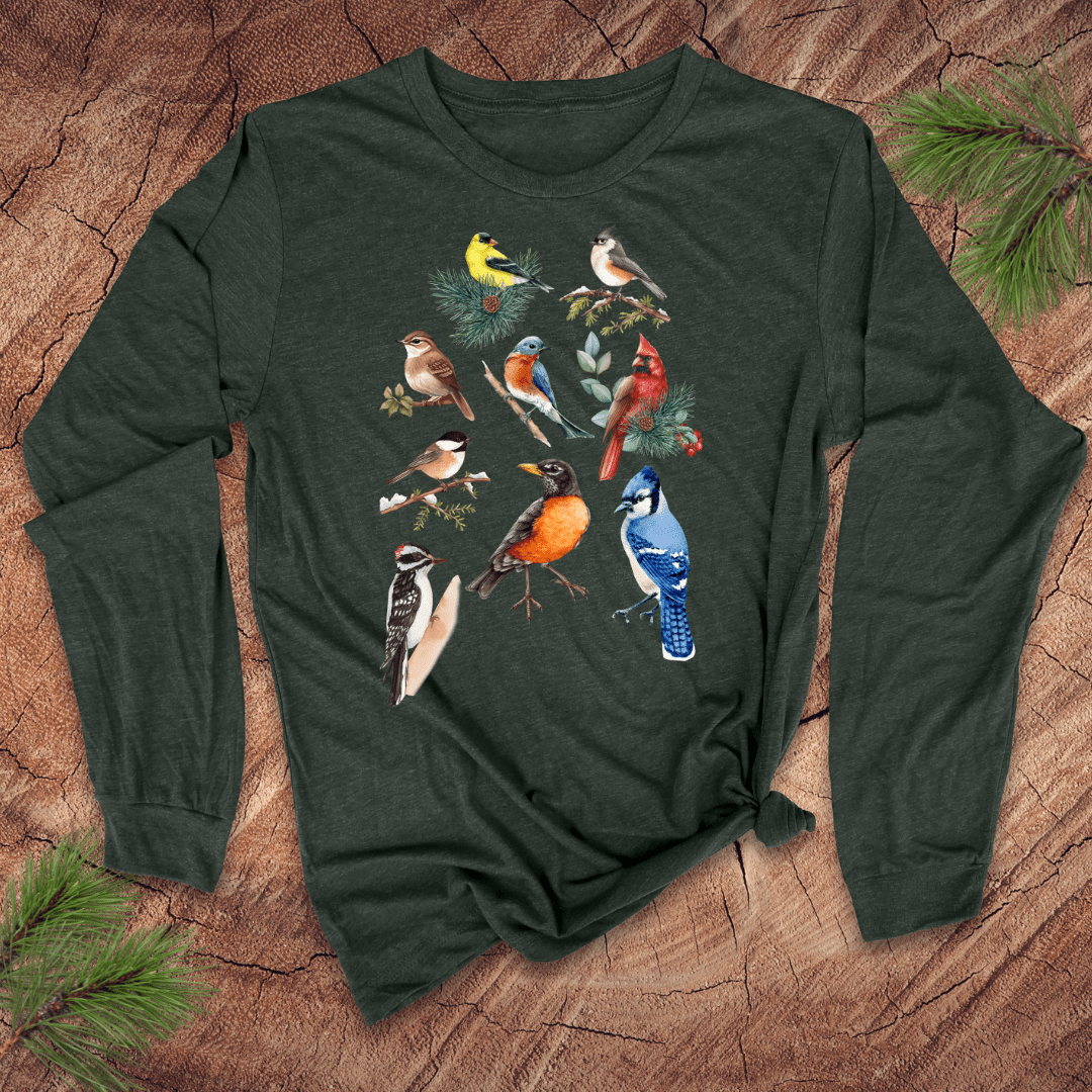 Green long-sleeve shirt with bird illustrations on a wooden surface