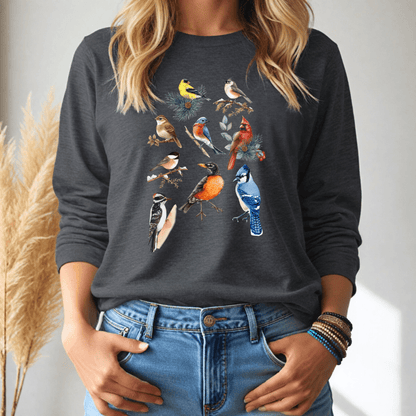 Person wearing a dark gray long sleeve tshirt with colorful bird illustrations, standing against a neutral background.