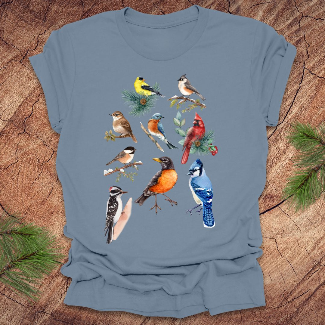 Blue t-shirt with bird illustrations on a wooden surface