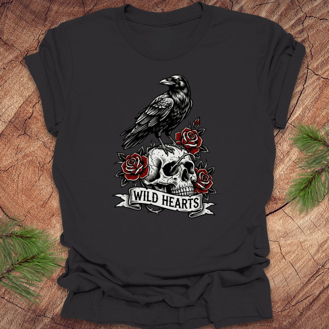 Dark gray t-shirt with a crow, skull, and roses design with text, 'wild hearts' on a wooden surface.
