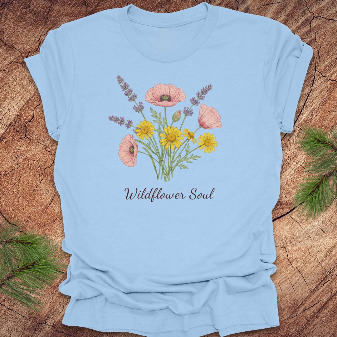 Light blue t-shirt with floral design and 'Wildflower Soul' text on a wooden surface.