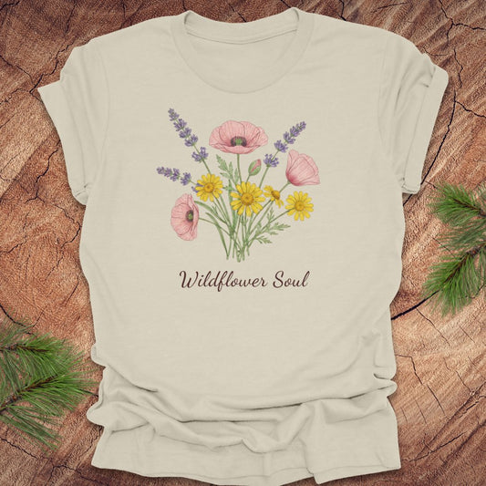 Beige t-shirt with floral design and 'Wildflower Soul' text on a wooden surface