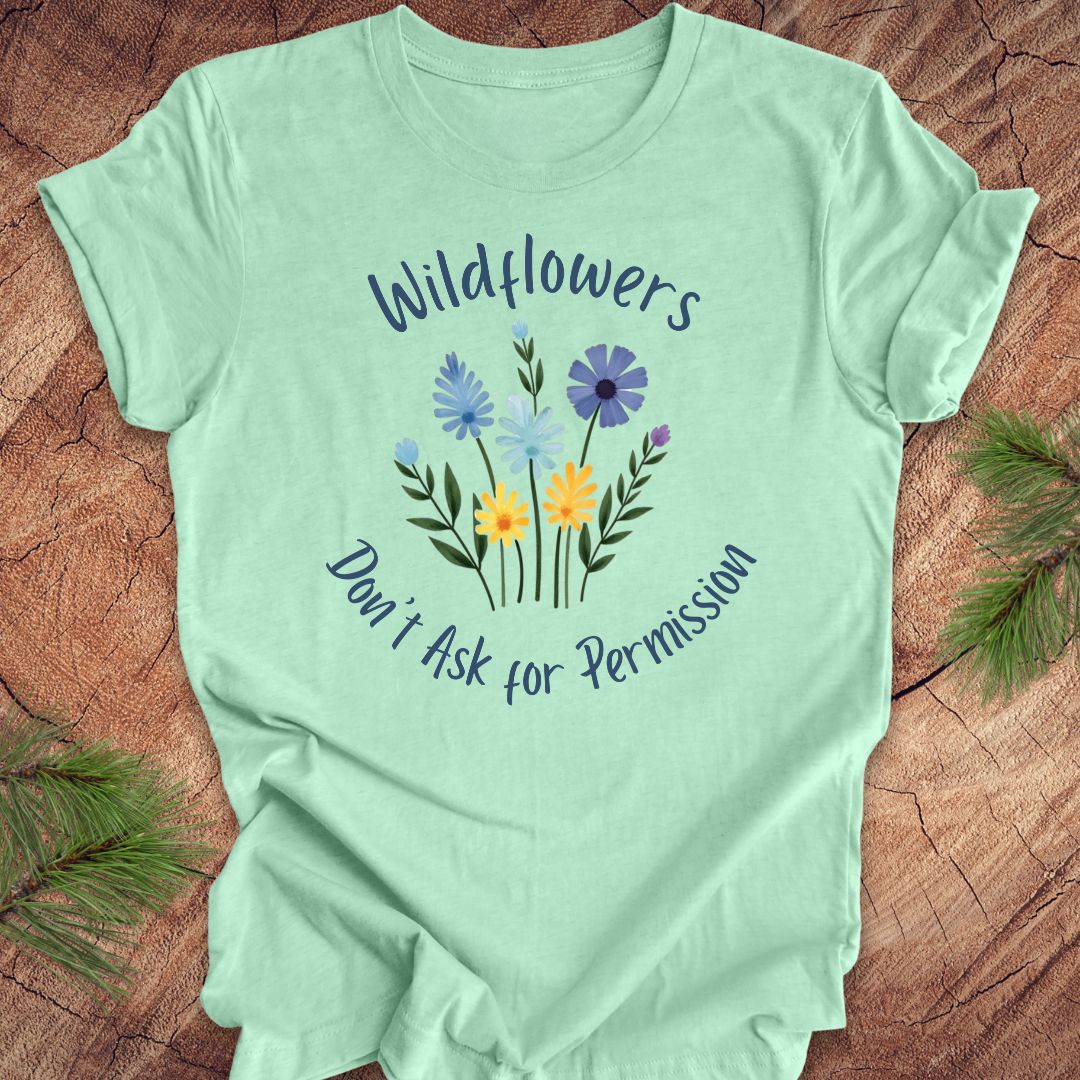 Mint green t-shirt with floral design and text on a wooden surface