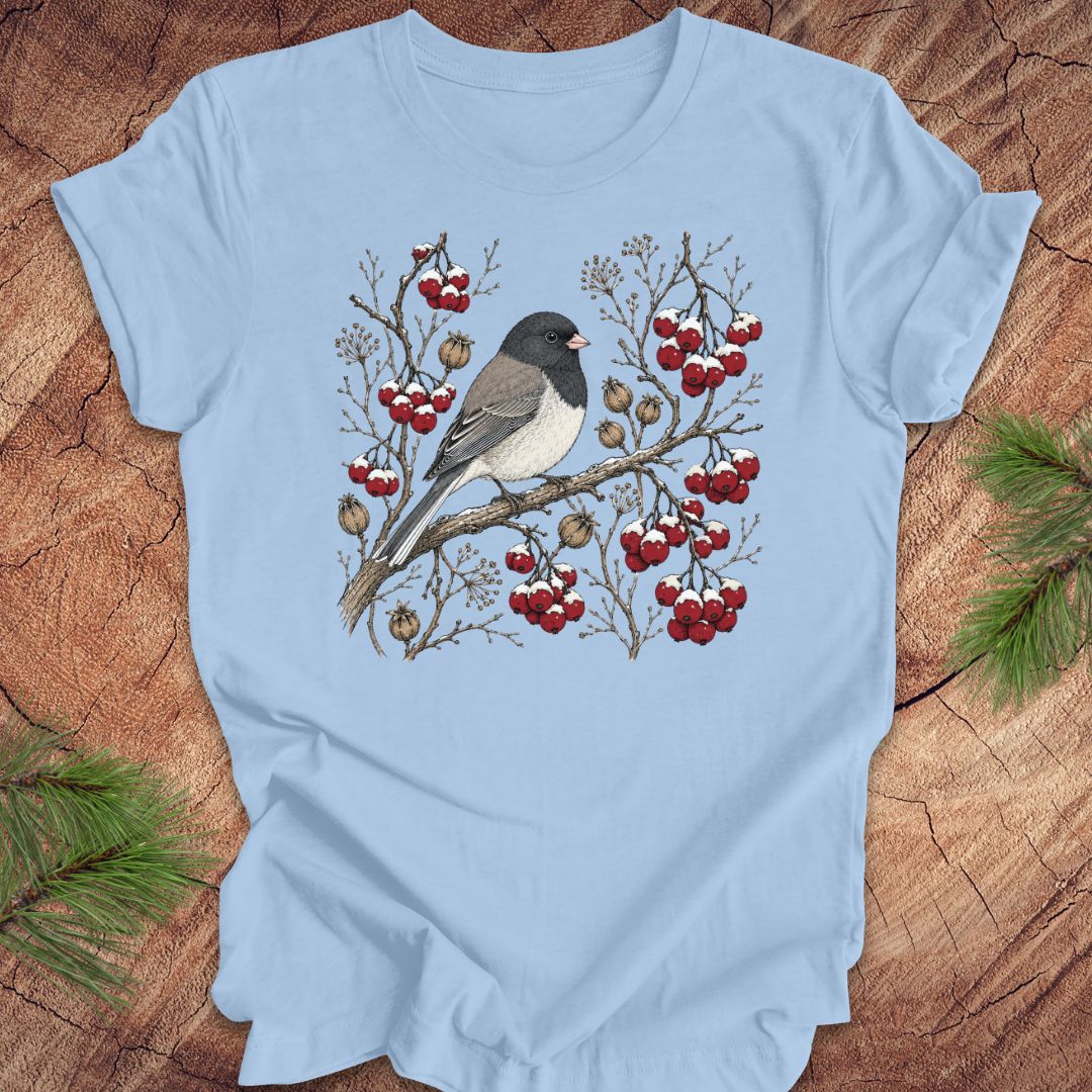 Light blue t-shirt with a dark eyed junco bird and berry design on a wooden surface