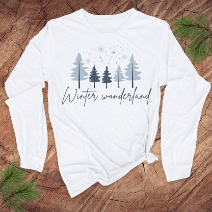 White long-sleeve shirt with 'Winter wonderland' text and tree design on a wooden surface.