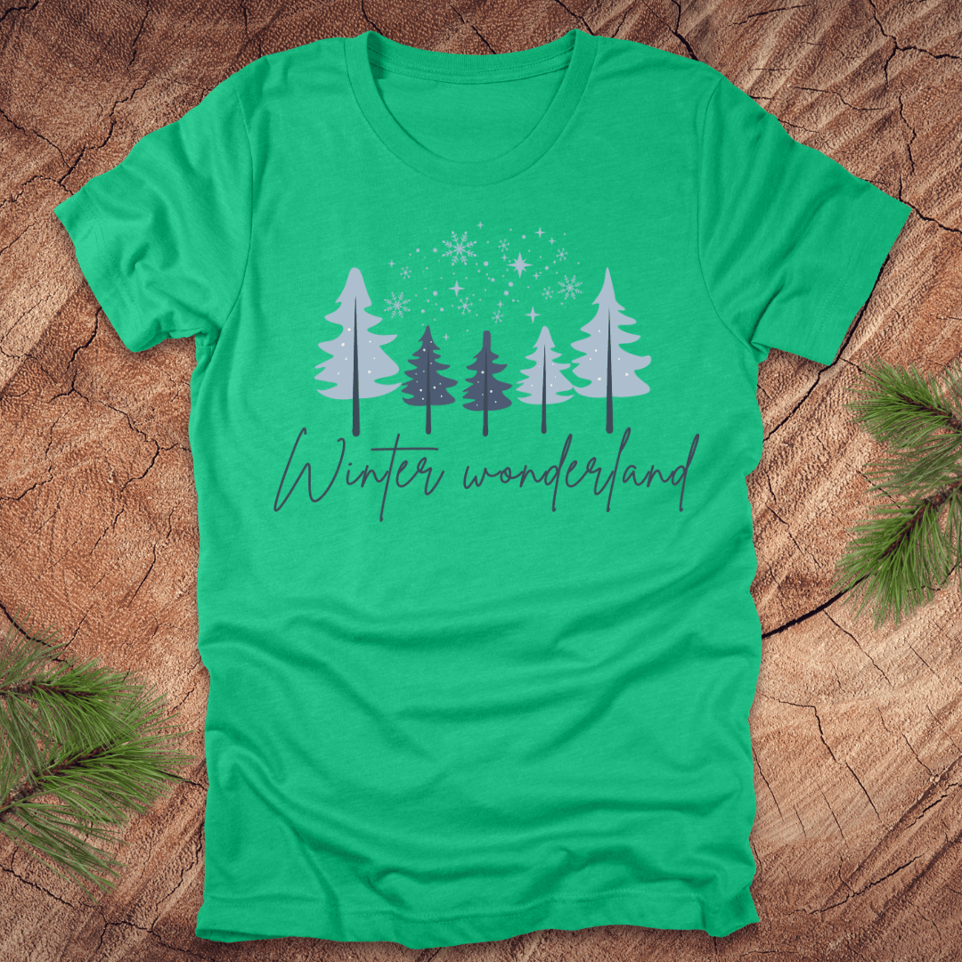 Green t-shirt with 'Winter wonderland' text and trees with snow design on a wooden surface