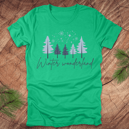 Green t-shirt with 'Winter wonderland' text and trees with snow design on a wooden surface