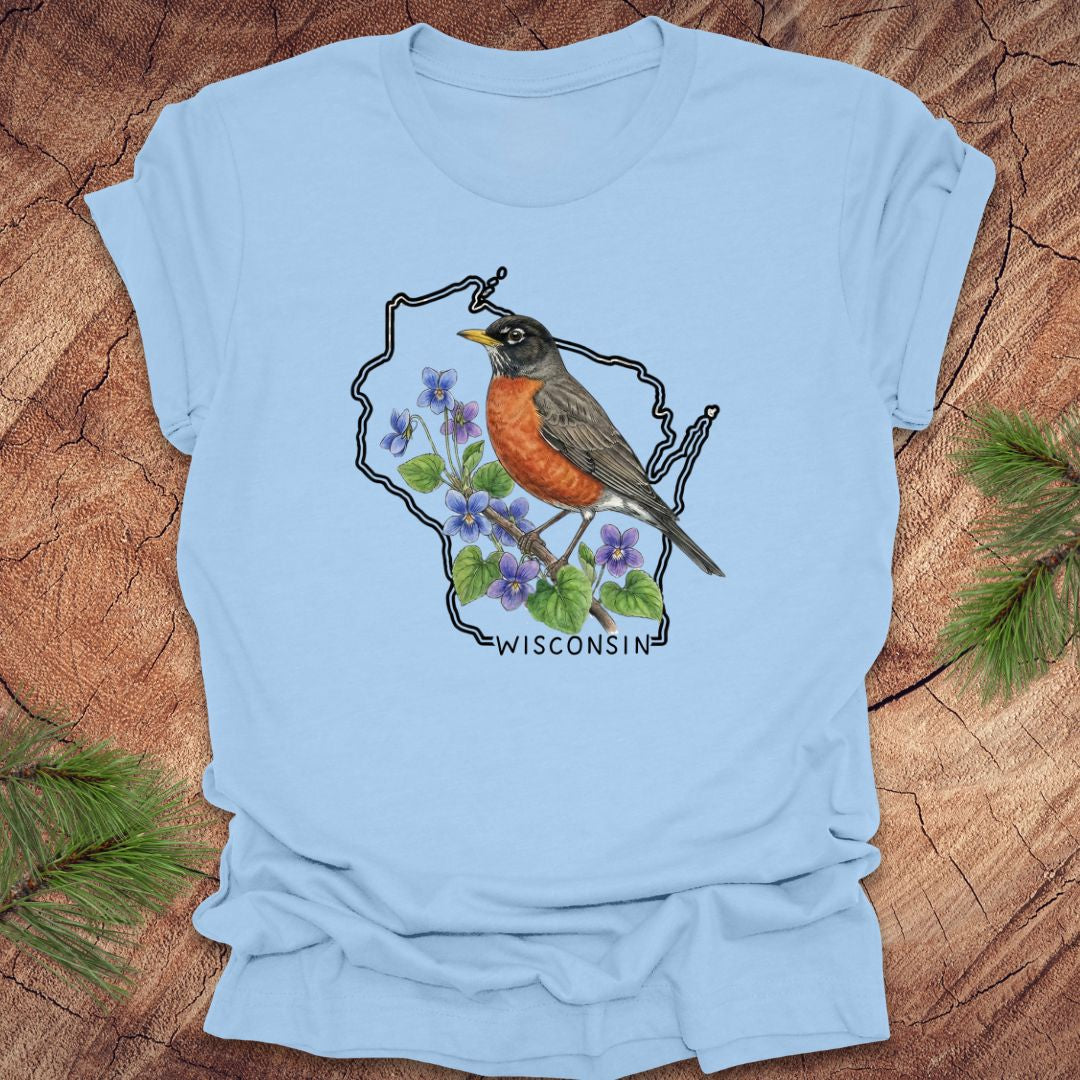 Light blue t-shirt with a robin and floral design inside Wisconsin state outline on a wooden surface