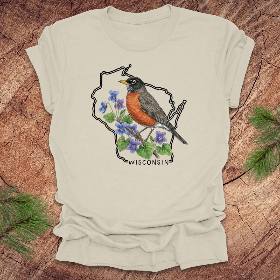 Beige t-shirt with a robin and floral design inside Wisconsin state outline on a wooden surface