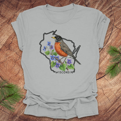 Light gray t-shirt with a robin and floral design inside Wisconsin state outline on a wooden surface