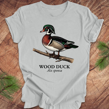Gray t-shirt with a wood duck graphic and text on a wooden surface.