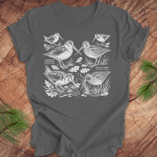 Gray t-shirt with woodcock and snipe illustrations on a wooden surface