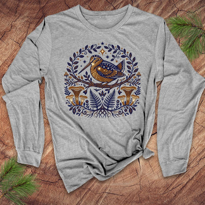 Gray long-sleeve shirt with a woodcock nature-themed design featuring a bird and plants on a wooden surface.