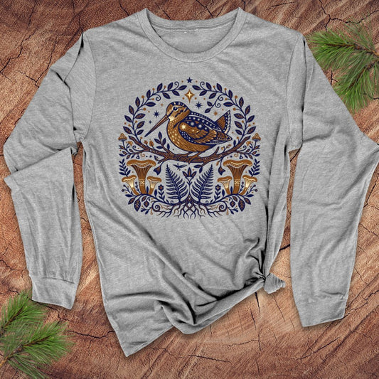 Gray long-sleeve shirt with a woodcock nature-themed design featuring a bird and plants on a wooden surface.