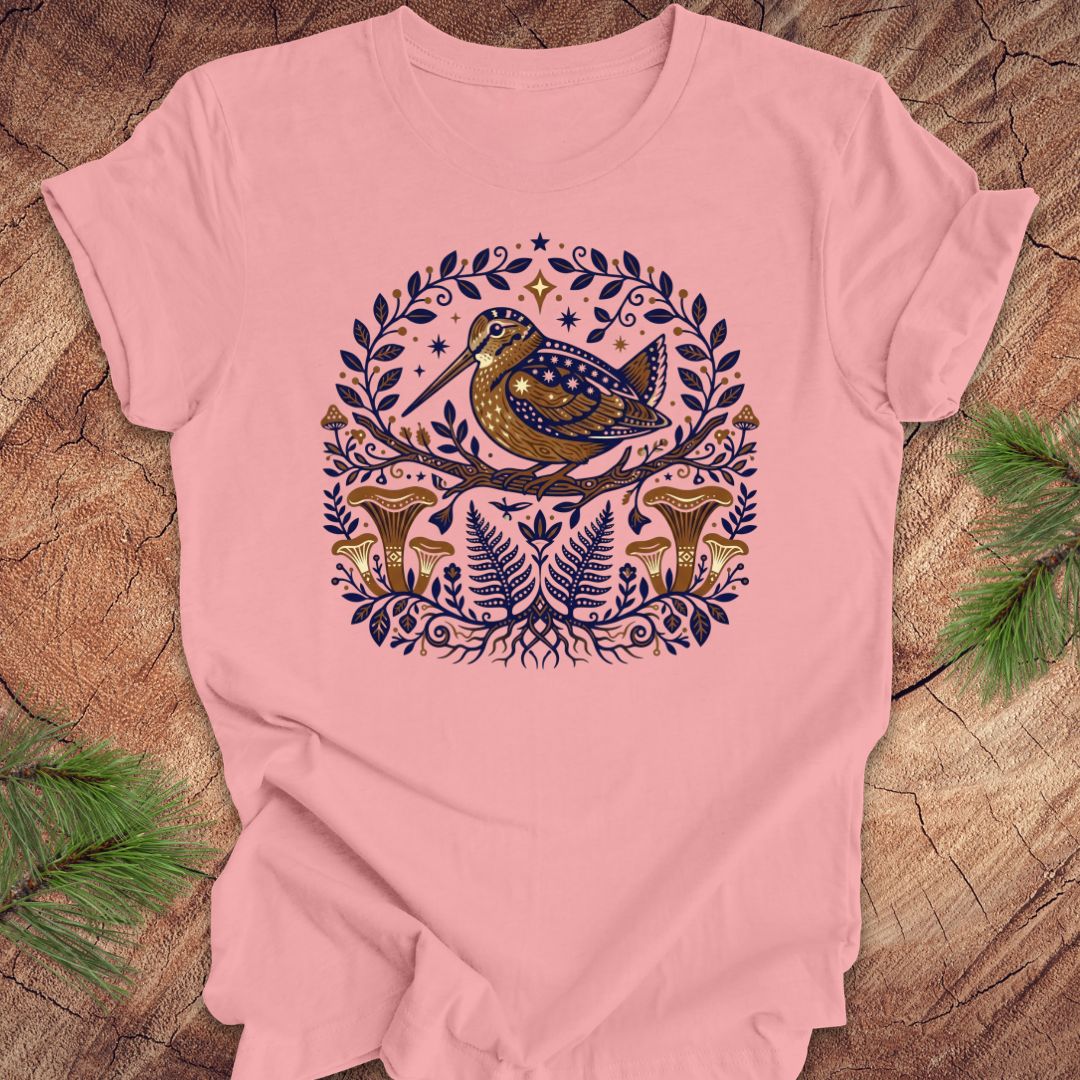 Pink t-shirt with a woodcock and mushroom design on a wooden surface