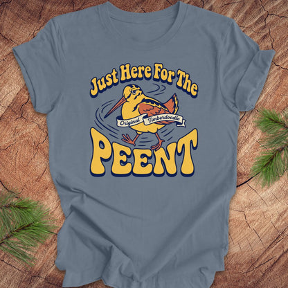 Blue t-shirt with 'Just Here For The Peent' woodcock graphic on a wooden surface