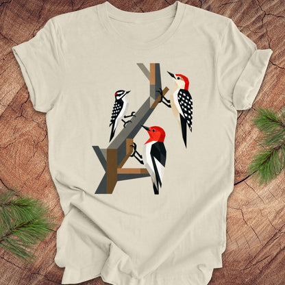 Beige t-shirt with woodpecker design on a wooden surface
