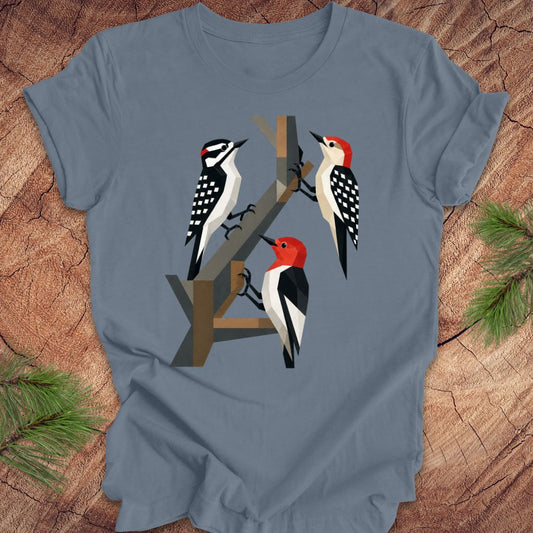 Blue t-shirt with woodpecker design on a wooden surface