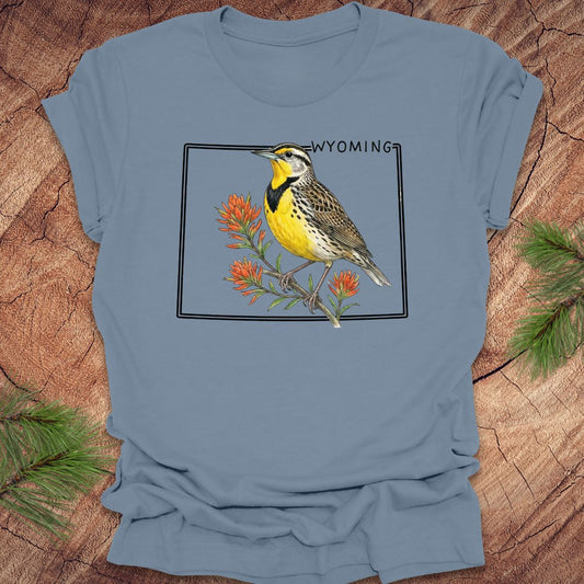 Blue t-shirt with a bird graphic and 'Wyoming' text on a wooden surface