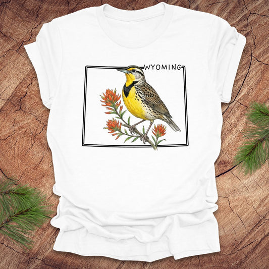 White t-shirt with a bird graphic and 'Wyoming' text on a wooden surface