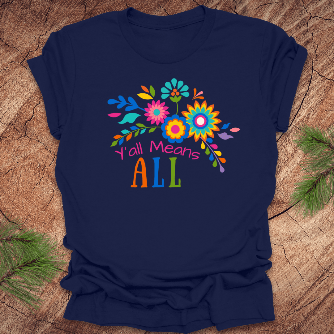 Navy blue t-shirt with colorful floral design and text 'Y'all Means All' on a wooden surface