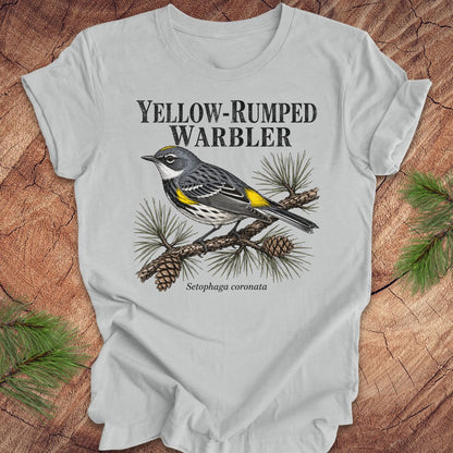 Gray t-shirt with yellow-rumped warbler graphic and text on a wooden surface.