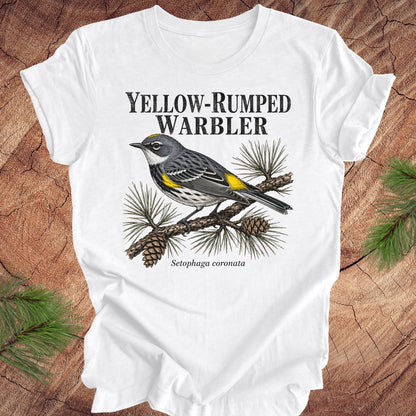 White t-shirt with yellow-rumped warbler graphic and text on a wooden surface.