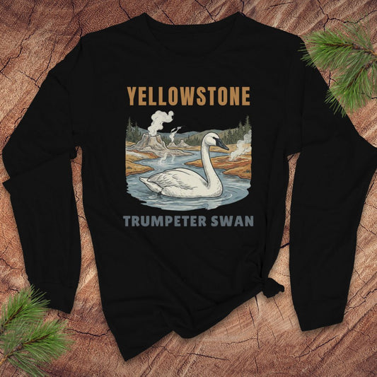 Black long-sleeve tshirt with Yellowstone Trumpeter Swan design on a wooden surface
