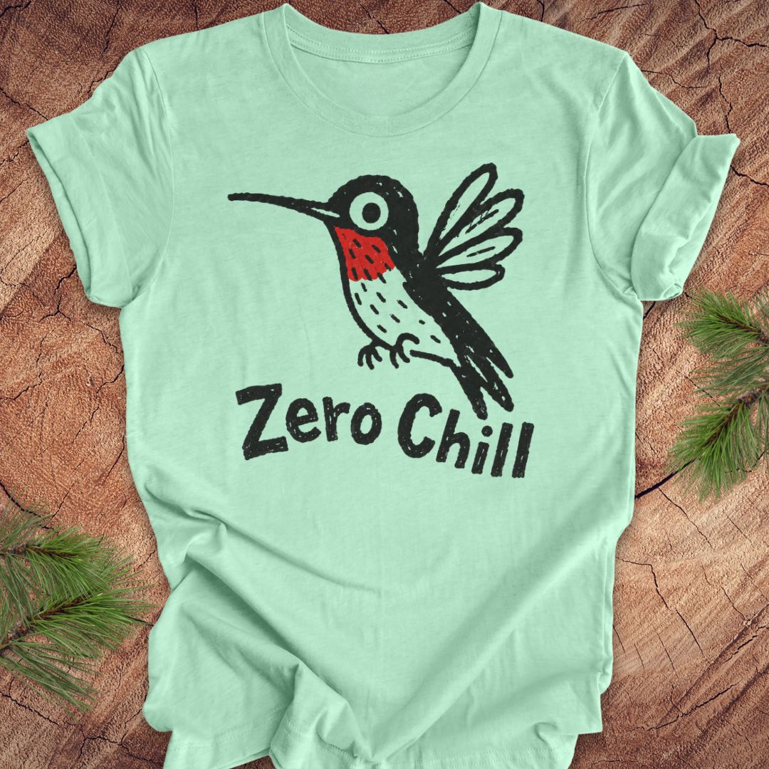 Mint green t-shirt with a black and red hummingbird graphic and 'Zero Chill' text on a wooden surface.