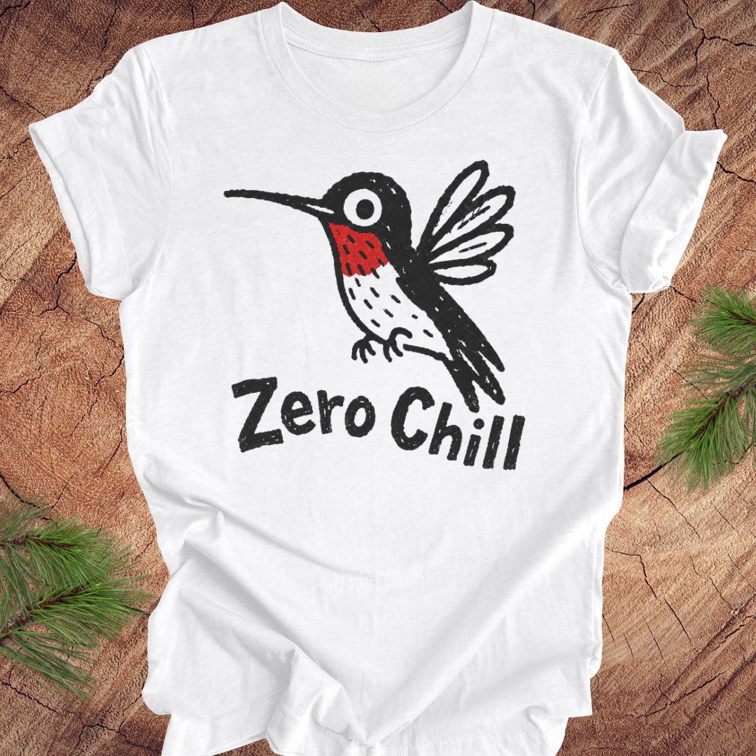 White t-shirt with a black and red hummingbird graphic and 'Zero Chill' text on a wooden surface.