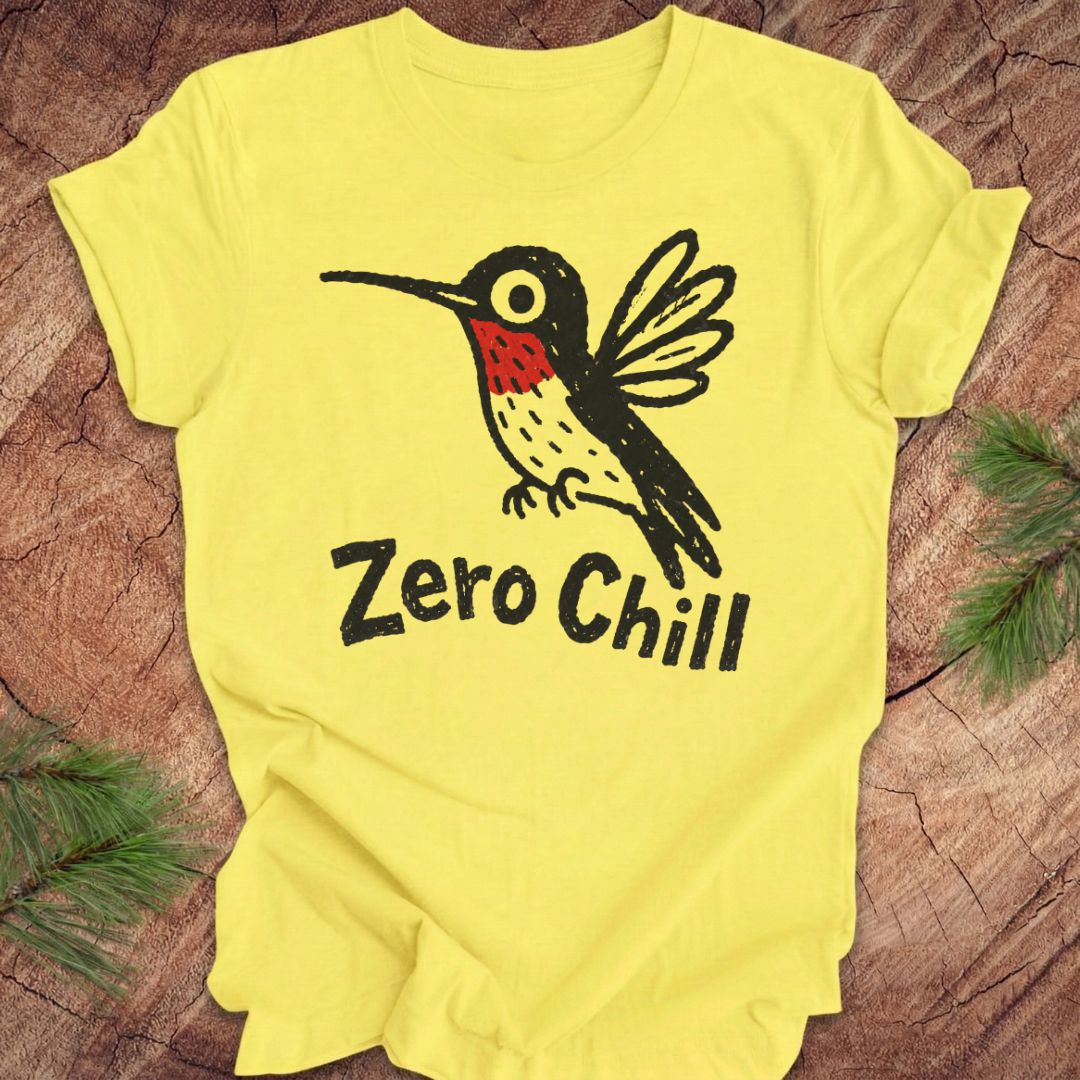 Yellow t-shirt with a black and red hummingbird graphic and 'Zero Chill' text on a wooden surface.